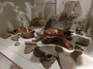 Zo liggen de scherven uit Stavoren er tegenwoordig bij. In een vitrinekast, opnieuw tentoongesteld. Op de achtergrond mooie agaat-stenen die we ooit in een zomervakantie in Frankrijk verzameld hebben.  